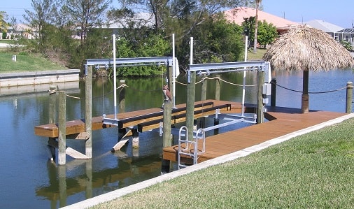 Waterfront dock with boat lift and tiki hut