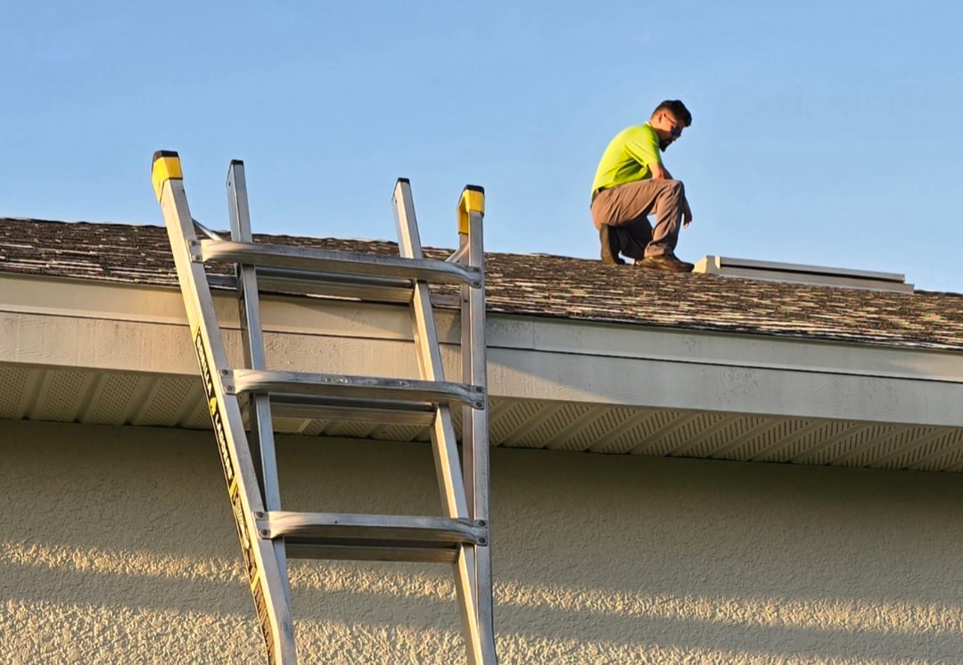 Sherlock Home Inspections — inspector on roof with ladder performing roof certification inspection