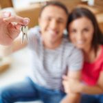 Hand of young man showing keys from new flat